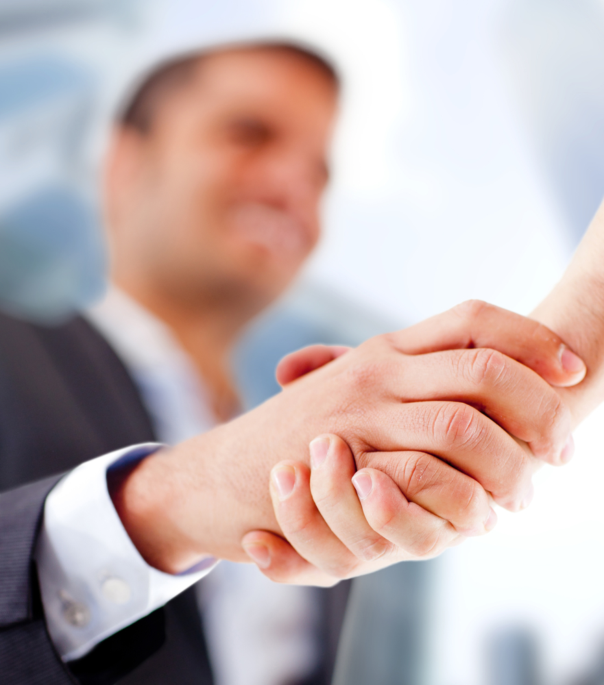 Business man closing a deal with a handshake Business man closing a deal with a handshake